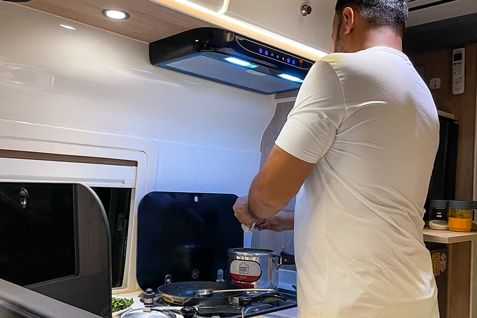 Caravan kitchenette with chimney, gas stove and cooking utensils in Delhi NCR